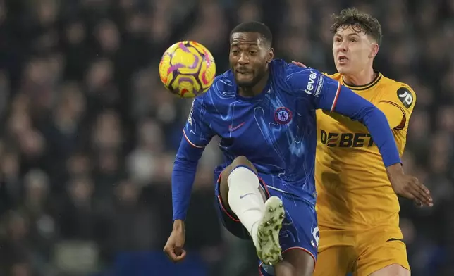 Chelsea's Tosin Adarabioyo, left, duels for the ball with Wolverhampton Wanderers' Jorgen Strand Larsen during the English Premier League soccer match between Chelsea and Wolverhampton at Stamford Bridge stadium in London, Monday, Jan. 20, 2025. (AP Photo/Kin Cheung)