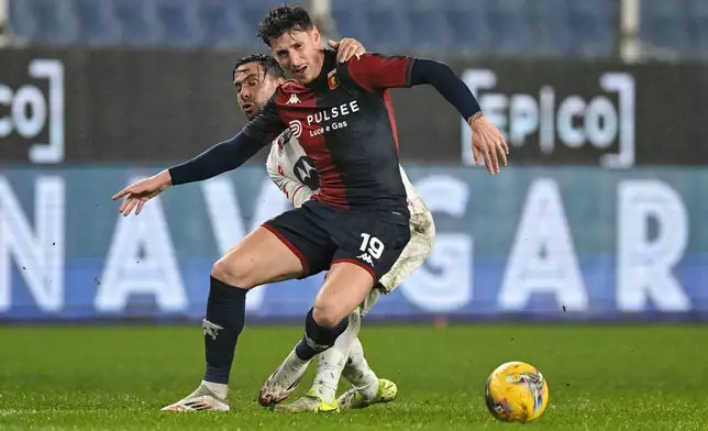 Genoa's Andrea Pinamonti, front, and Monza's Armando Izzo in action during the Serie A soccer match between Genoa and Monza at the Luigi Ferraris Stadium in Genoa, Italy, Monday, Jan. 27, 2025. (Tano Pecoraro/LaPresse via AP)