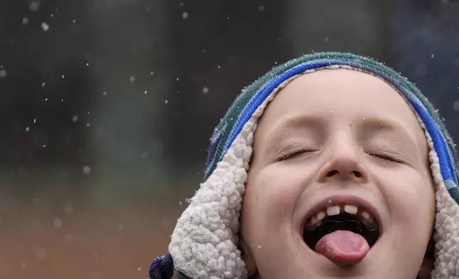 A child catches snowflakes with their tongue during El Museo del Barrio's 47th annual Three Kings Day parade, Monday, Jan. 6, 2025, in New York. (AP Photo/Julia Demaree Nikhinson)