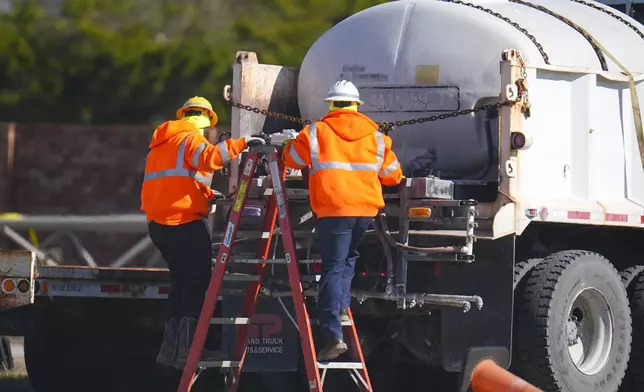 Workers labor on a brine truck at the Texas Department of Transportation Dallas Southwest lot as crews prepare the roads ahead of a winter storm expected to hit the North Texas region, Tuesday, Jan. 7, 2025, in Cedar Hill, Texas. (AP Photo/Julio Cortez)