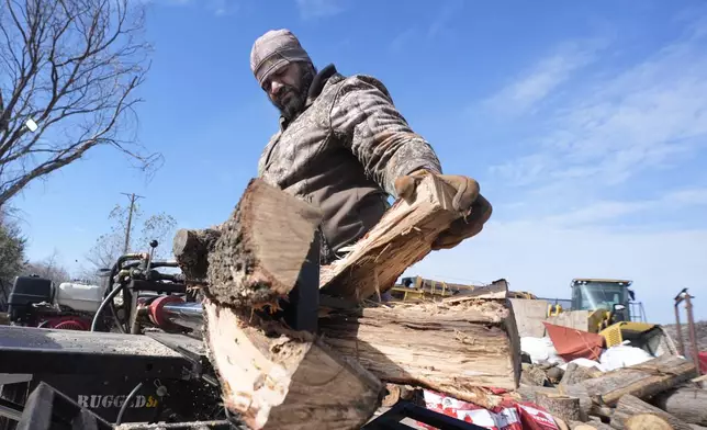 Sterling Howard splits logs for firewood ahead of a winter storm expected to hit the North Texas region later tomorrow Wednesday, Jan. 8, 2025, in Dallas. (AP Photo/LM Otero)