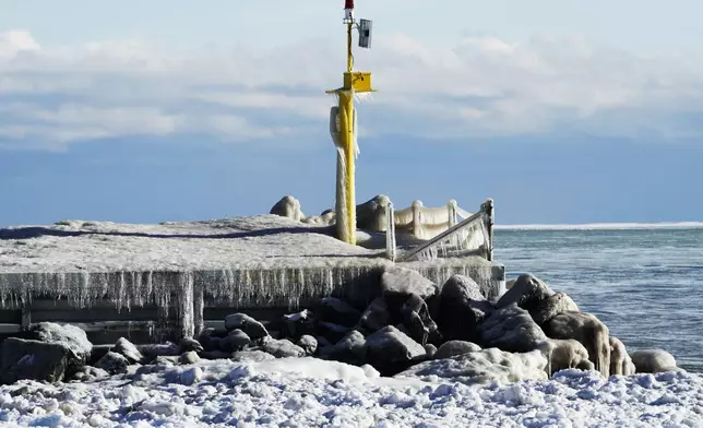 A harbor light is covered by ice at the church street power boat ramp on during cold weather in Evanston, Ill., Wednesday, Jan. 8, 2025. (AP Photo/Nam Y. Huh)