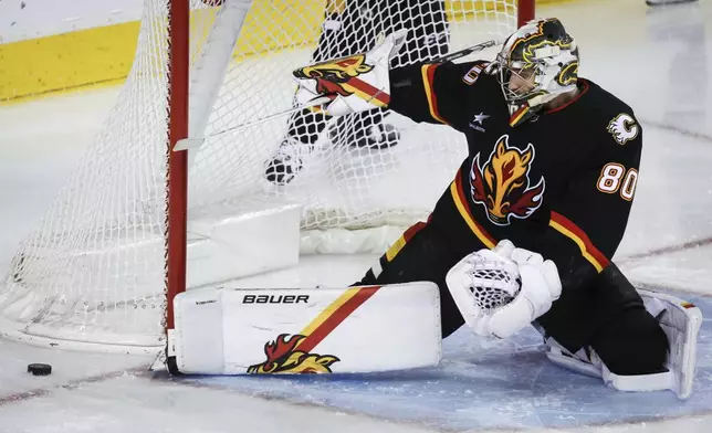 Calgary Flames goalie Dan Vladar kicks away a shot during the second period of an NHL hockey game against the Utah Hockey Club in Calgary, Alberta, Thursday, Jan. 2, 2025. (Jeff McIntosh/The Canadian Press via AP) AP)