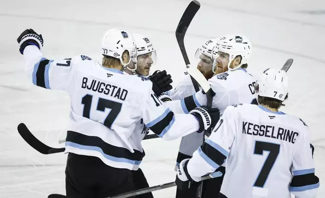 Utah Hockey Club's Lawson Crouse, second right, celebrates his goal with teammates during the first period of an NHL hockey game against the Calgary Flames in Calgary, Alberta, Thursday, Jan. 2, 2025. (Jeff McIntosh/The Canadian Press via AP)