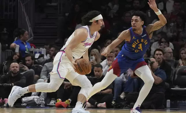 Miami Heat guard Jaime Jaquez Jr., left, drives to the basket as Denver Nuggets guard Julian Strawther (3) defends during the first half of an NBA basketball game, Friday, Jan. 17, 2025, in Miami. (AP Photo/Lynne Sladky)