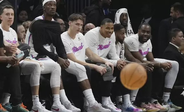Miami Heat forward Jimmy Butler, second from left, looks on from the bench during the first half of an NBA basketball game against the Denver Nuggets, Friday, Jan. 17, 2025, in Miami. (AP Photo/Lynne Sladky)