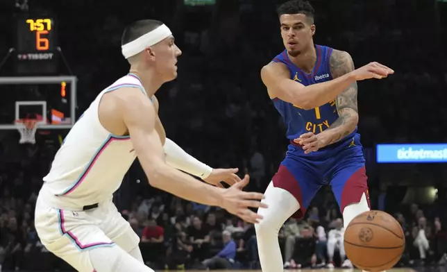 Denver Nuggets forward Michael Porter Jr. (1) passes the ball as Miami Heat guard Tyler Herro, left, defends during the first half of an NBA basketball game, Friday, Jan. 17, 2025, in Miami. (AP Photo/Lynne Sladky)
