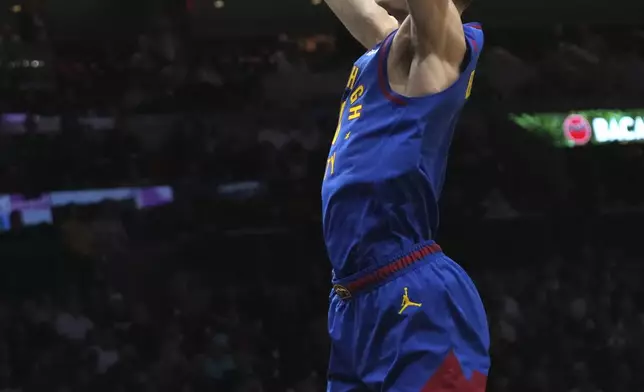 Denver Nuggets guard Christian Braun, top, dunks over Miami Heat guard Jaime Jaquez Jr. (11) during the first half of an NBA basketball game, Friday, Jan. 17, 2025, in Miami. (AP Photo/Lynne Sladky)