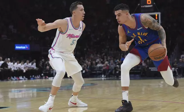 Miami Heat forward Duncan Robinson defends Denver Nuggets forward Michael Porter Jr. (1) during the first half of an NBA basketball game, Friday, Jan. 17, 2025, in Miami. (AP Photo/Lynne Sladky)