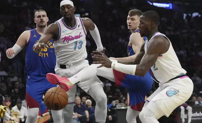 Denver Nuggets center Nikola Jokic, left, Miami Heat center Bam Adebayo (13), Nuggets guard Christian Braun, second from right, and Heat guard Terry Rozier, right, go for the ball during the first half of an NBA basketball game, Friday, Jan. 17, 2025, in Miami. (AP Photo/Lynne Sladky)