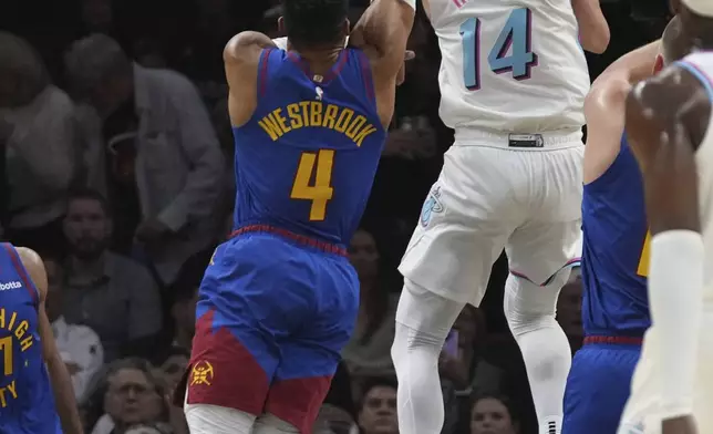 Miami Heat guard Tyler Herro (14) shoots as Denver Nuggets guard Russell Westbrook (4) defends during the first half of an NBA basketball game, Friday, Jan. 17, 2025, in Miami. (AP Photo/Lynne Sladky)