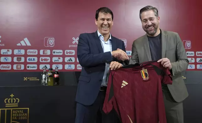 Newly appointed coach for Belgium's national team Red Devils Rudi Garcia, left, holds a national team jersey as he poses with sports director Vincent Mannaert after a media conference in Tubize, Friday, Jan. 24, 2025. (AP Photo/Virginia Mayo)