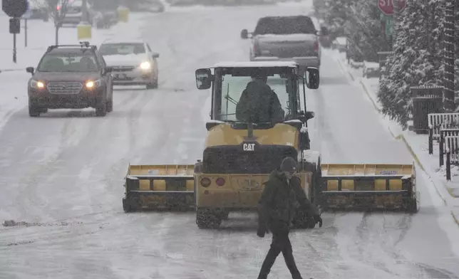 A plow clears a parking lot during a winter storm, Sunday, Jan. 5, 2025, in Cincinnati. (AP Photo/Joshua A. Bickel)