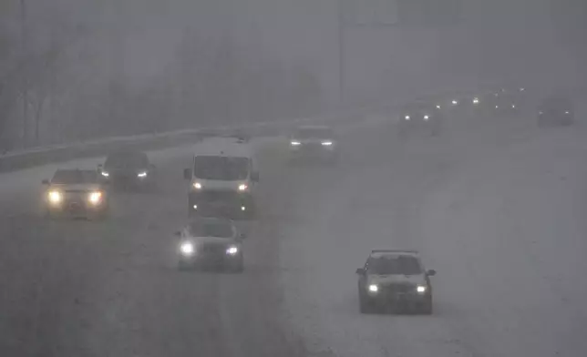 Vehicles drive along a highway during a winter storm, Sunday, Jan. 5, 2025, in Cincinnati. (AP Photo/Joshua A. Bickel)