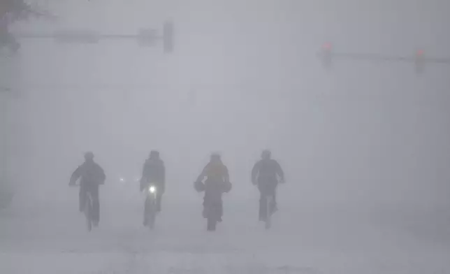 A group of cyclists make way through downtown Wichita, Kan., during a severe winter storm on Sunday, Jan. 5, 2025. (Travis Heying/The Wichita Eagle via AP)