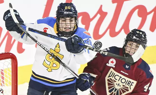 Toronto Sceptres' Sarah Nurse (20) and Montreal Victoire's Amanda Boulier (44) challenge for the puck during second-period PWHL hockey game action in Laval, Quebec, Thursday, Jan. 30, 2025. (Graham Hughes/The Canadian Press via AP)