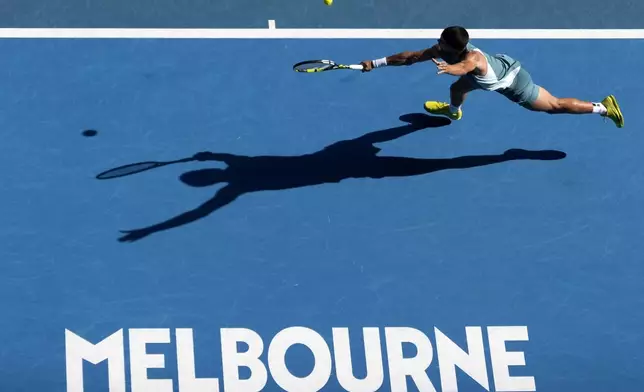 Carlos Alcaraz of Spain returns a shot against Jack Draper of Britain during a fourth round match at the Australian Open tennis championship in Melbourne, Australia, Sunday, Jan. 19, 2025. (AP Photo/Asanka Brendon Ratnayake)