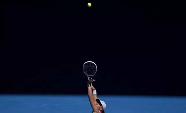 Iga Swiatek of Poland serves to Emma Navarro of the U.S. during their quarterfinal match at the Australian Open tennis championship in Melbourne, Australia, Wednesday, Jan. 22, 2025. (AP Photo/Ng Han Guan)