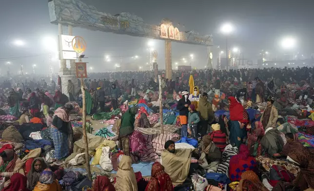 Hindu devotees rest by the banks of the Sangam, the confluence of the Ganges, the Yamuna and the mythical Saraswati rivers, on the eve of Mauni Amavasya' or new moon day during the Maha Kumbh festival, in Prayagraj, Uttar Pradesh, India, Tuesday, Jan. 28, 2025. (AP Photo/Rajesh Kumar Singh)