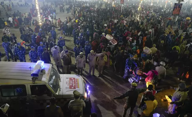 Security officials make way for an ambulance as Hindu devotees gather for a holy dip by the banks of the Sangam, the confluence of the Ganges, the Yamuna and the mythical Saraswati rivers, on Mauni Amavasya' or new moon day during the Maha Kumbh festival in Prayagraj, Uttar Pradesh, India, Wednesay, Jan. 29, 2025. (AP Photo/Deepak Sharma)