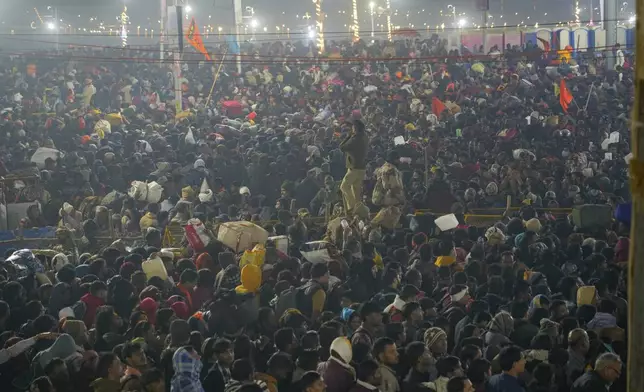 Hindu devotees gather for a holy dip by the banks of the Sangam, the confluence of the Ganges, the Yamuna and the mythical Saraswati rivers, on Mauni Amavasya' or new moon day during the Maha Kumbh festival in Prayagraj, Uttar Pradesh, India, Wednesay, Jan. 29, 2025. (AP Photo/Deepak Sharma)