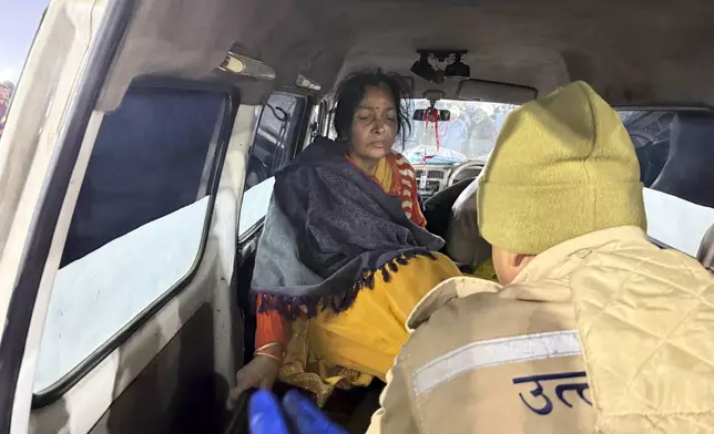 A woman injured in a stampede is helped into an ambulance by the banks of the Sangam, the confluence of the Ganges, the Yamuna and the mythical Saraswati rivers, on Mauni Amavasya' or new moon day during the Maha Kumbh festival, in Prayagraj, Uttar Pradesh, India, Wednesday, Jan. 29, 2025. (AP Photo/Rajesh Kumar Singh)