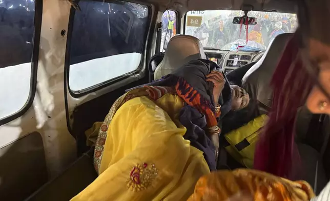 A woman injured in a stampede lies in an ambulance by the banks of the Sangam, the confluence of the Ganges, the Yamuna and the mythical Saraswati rivers, on 'Mauni Amavasya' or new moon day during the Maha Kumbh festival, in Prayagraj, Uttar Pradesh, India, Wednesday, Jan. 29, 2025. (AP Photo/Rajesh Kumar Singh)