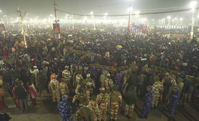 Security officers stand guard at the site of a stampede on the Sangam, the confluence of the Ganges, the Yamuna and the mythical Saraswati rivers, on "Mauni Amavasya" or new moon day during the Maha Kumbh festival, in Prayagraj, Uttar Pradesh, India, Wednesday, Jan. 29, 2025. (AP Photo)