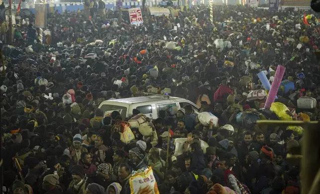 Am ambulance moves in the middle of a crowd of Hindu devotees gathered for a holy dip by the banks of the Sangam, the confluence of the Ganges, the Yamuna and the mythical Saraswati rivers, on Mauni Amavasya' or new moon day during the Maha Kumbh festival in Prayagraj, Uttar Pradesh, India, Wednesay, Jan. 29, 2025. (AP Photo/Deepak Sharma)