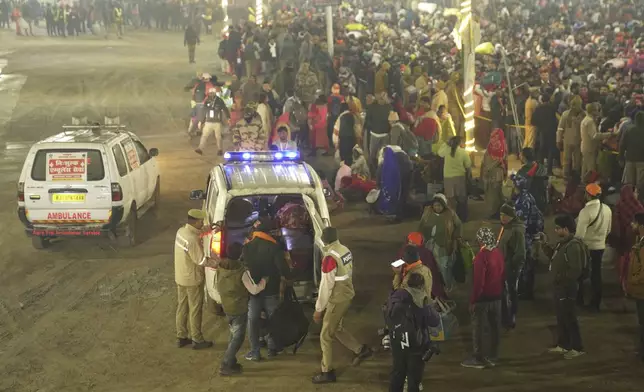 Security officers guide devotees into an ambulance at the site of a stampede on the Sangam, the confluence of the Ganges, the Yamuna and the mythical Saraswati rivers, on "Mauni Amavasya" or new moon day during the Maha Kumbh festival, in Prayagraj, Uttar Pradesh, India, Wednesday, Jan. 29, 2025. (AP Photo)