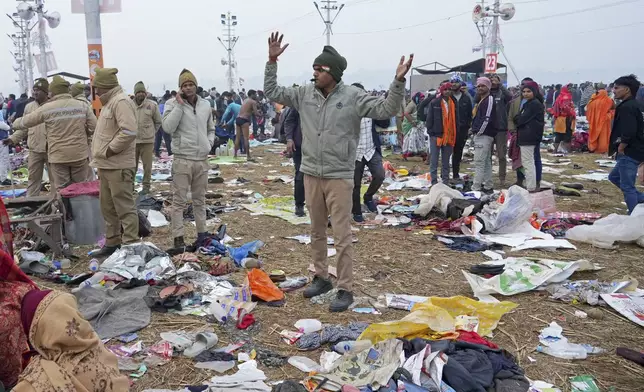 A policeman gestures as the belongings of Hindu devotees lie scattered after a stampede when Hindu devotees rushed to take a holy bath in the Sangam, the confluence of the Ganges, the Yamuna and the mythical Saraswati rivers, on "Mauni Amavasya" or new moon day during the Maha Kumbh festival in Prayagraj, India, Wednesday, Jan. 29, 2025. (AP Photo/Deepak Sharma)