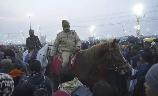 Policemen control the crowd as Hindu devotees gather to take a holy dip by the banks of the Sangam, the confluence of the Ganges, the Yamuna and the mythical Saraswati rivers, on "Mauni Amavasya" or new moon day during the Maha Kumbh festival in Prayagraj, Uttar Pradesh, India, Wednesday, Jan. 29, 2025. (AP Photo/Deepak Sharma)