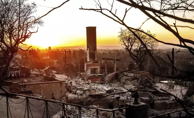 The sun rises behind a home destroyed by the Palisades Fire in the Pacific Palisades community of Los Angeles on Sunday, Jan. 12, 2025, (AP Photo/Noah Berger)