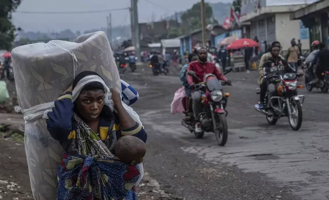 People displaced by the fighting with M23 rebels make their way to the center of Goma, Democratic Republic of the Congo, Sunday, Jan. 26, 2025. (AP Photo/Moses Sawasawa)