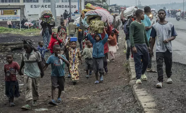 People displaced by the fighting with M23 rebels make their way to the center of Goma, Democratic Republic of the Congo, Sunday, Jan. 26, 2025. (AP Photo/Moses Sawasawa)