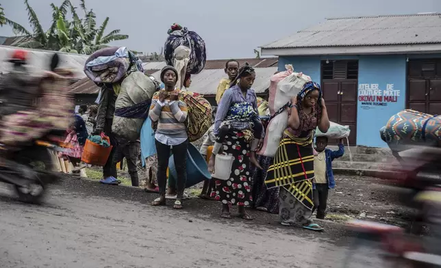 People displaced by the fighting with M23 rebels make their way to the center of Goma, Democratic Republic of the Congo, Sunday, Jan. 26, 2025. (AP Photo/Moses Sawasawa)