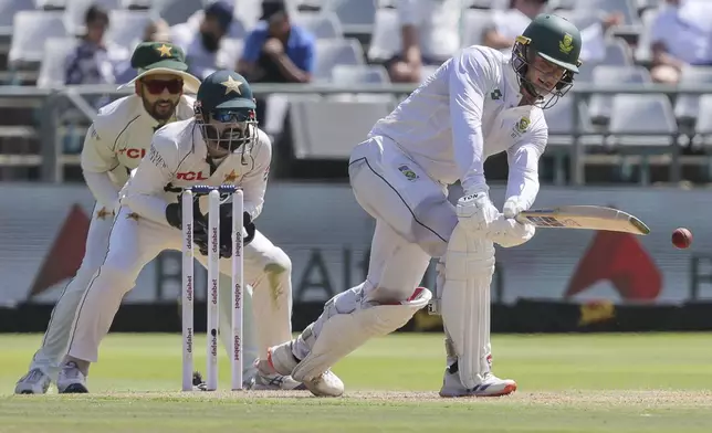 South Africa's Ryan Rickelton plays a shot while Pakistan's Mohammad Rizwan and Pakistan's Babar Azam look on during the second test match between South Africa and Pakistan in Cape Town, South Africa, Friday, Jan. 3, 2025. (AP Photo/Halden Krog)