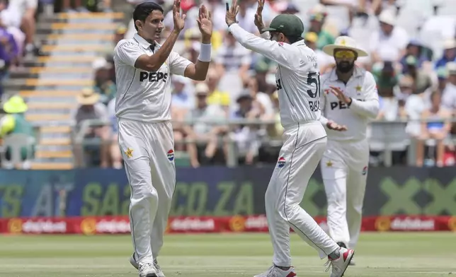 Pakistan's Mohammad Abbas and Babar Azam celebrate the wicket of South Africa's Wiaan Mulder, during the second test cricket match between South Africa and Pakistan, in Cape Town, South Africa, Friday, Jan. 3, 2025. (AP Photo/Halden Krog)