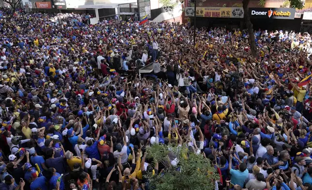 Supporters of Venezuelan opposition leader Maria Corina Machado surround the truck she waves from during a protest against Venezuelan President Nicolas Maduro the day before his inauguration for a third term in Caracas, Venezuela, Thursday, Jan. 9, 2025. (AP Photo/Ariana Cubillos)