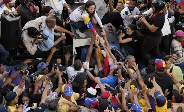 Venezuelan opposition leader Maria Corina Machado greets supporters at a protest against President Nicolas Maduro in Caracas, Venezuela, Thursday, Jan. 9, 2025, the day before his inauguration for a third term. (AP Photo/Ariana Cubillos)