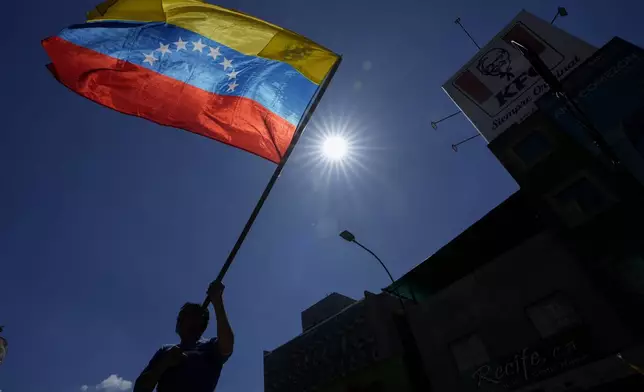 A man waves a flag during a protest by opponents of Venezuelan President Nicolas Maduro the day before his inauguration for a third term in Caracas, Venezuela, Thursday, Jan. 9, 2025. (AP Photo/Matias Delacroix)