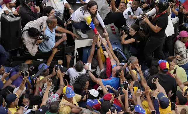 Venezuelan opposition leader Maria Corina Machado greets supporters during a protest against President Nicolas Maduro the day before his inauguration for a third term, in Caracas, Venezuela, Thursday, Jan. 9, 2025. (AP Photo/Ariana Cubillos)