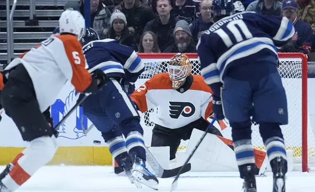Columbus Blue Jackets defenseman Zach Werenski, second from left, scores on Philadelphia Flyers goaltender Ivan Fedotov in the first period of an NHL hockey game Tuesday, Jan. 14, 2025, in Columbus, Ohio. (AP Photo/Sue Ogrocki)