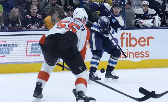 Columbus Blue Jackets' Cole Sillinger (4) shoots as Philadelphia Flyers' Rasmus Ristolainen (55) defends in the second period of an NHL hockey game Tuesday, Jan. 14, 2025, in Columbus, Ohio. (AP Photo/Sue Ogrocki)