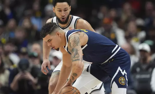 Denver Nuggets forward Michael Porter Jr., front, tries to control the ball as Brooklyn Nets guard Ben Simmons, top, defends in the first half of an NBA basketball game Friday, Jan. 10, 2025, in Denver. (AP Photo/David Zalubowski)
