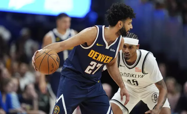 Denver Nuggets guard Jamal Murray, front, looks to drive to the basket as Brooklyn Nets guard Keon Johnson defends in the first half of an NBA basketball game Friday, Jan. 10, 2025, in Denver. (AP Photo/David Zalubowski)