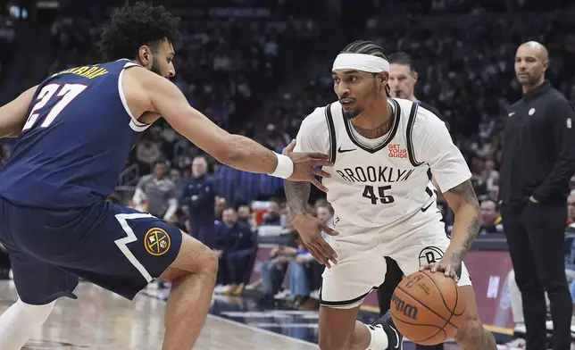 Brooklyn Nets guard Keon Johnson, right, drives to the basket as Denver Nuggets guard Jamal Murray defends in the first half of an NBA basketball game Friday, Jan. 10, 2025, in Denver. (AP Photo/David Zalubowski)