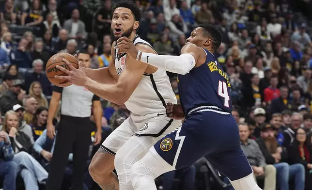 Brooklyn Nets guard Ben Simmons, left, heads to the basket as Denver Nuggets guard Russell Westbrook, right, defends in the first half of an NBA basketball game Friday, Jan. 10, 2025, in Denver. (AP Photo/David Zalubowski)
