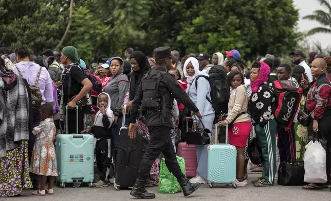 Rwanda security officials check people crossing from Congo in Gisenyi, Rwanda, Wednesday, Jan. 29, 2025, following M23 rebels' advances into eastern Congo's capital Goma. (AP Photo/Brian Inganga)