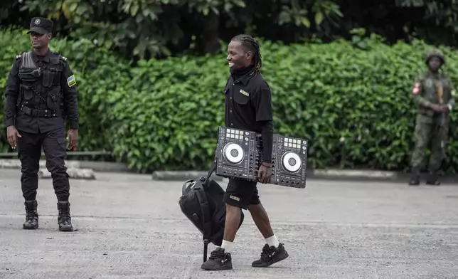 A man carries a Turntable as Rwanda security officials check people crossing from Congo in Gisenyi, Rwanda, Wednesday, Jan. 29, 2025, following M23 rebels' advances into eastern Congo's capital Goma. (AP Photo/Brian Inganga)